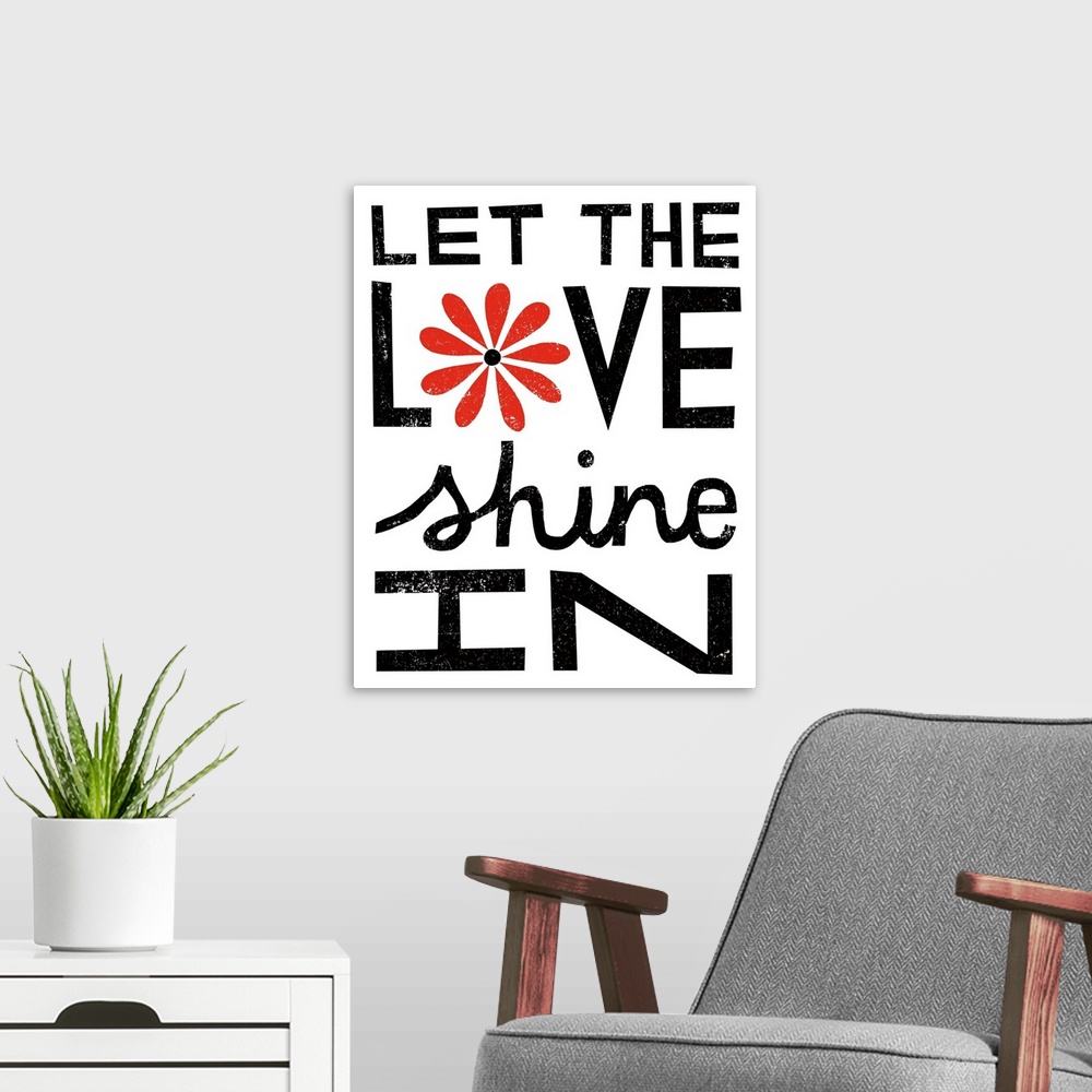 A modern room featuring "Let the love shine in" in bold black letters with a red flower.