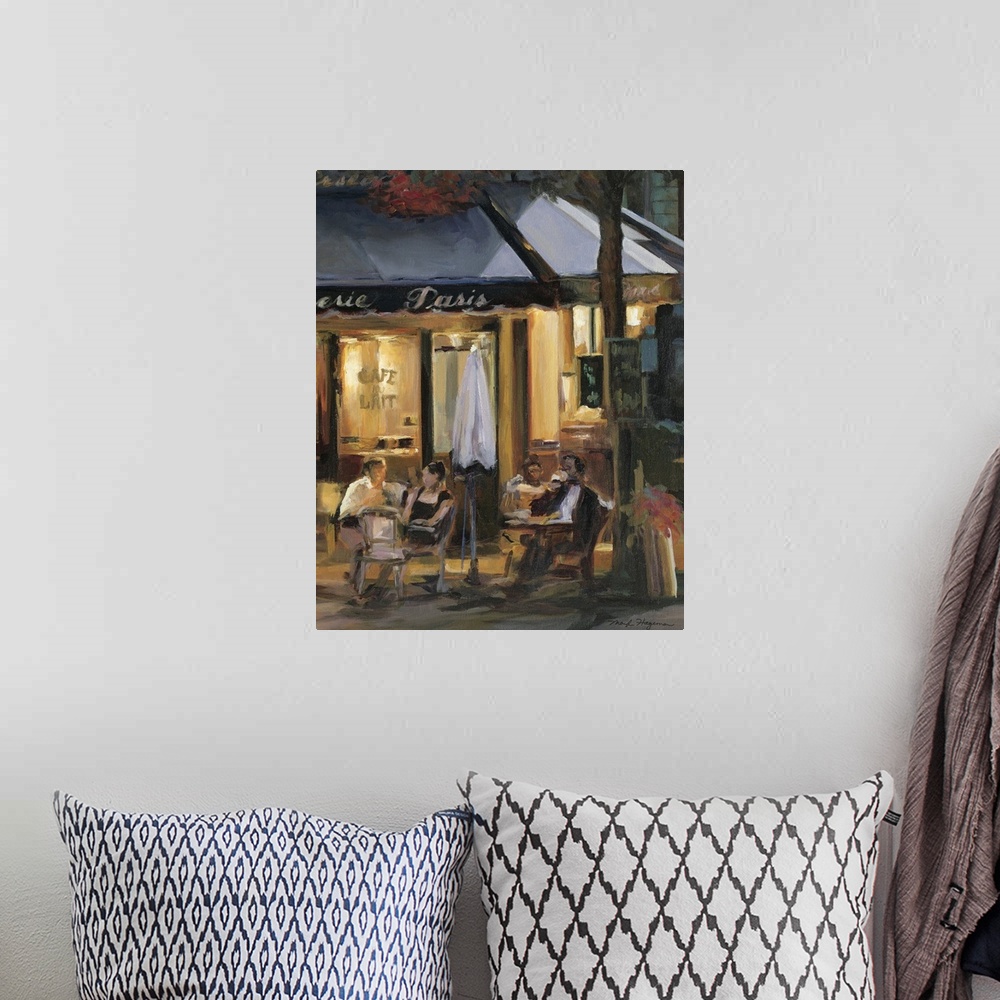 A bohemian room featuring Painting of street cafo with people sitting outside at tables at night.