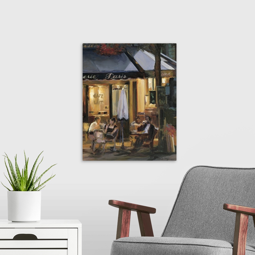 A modern room featuring Painting of street cafo with people sitting outside at tables at night.