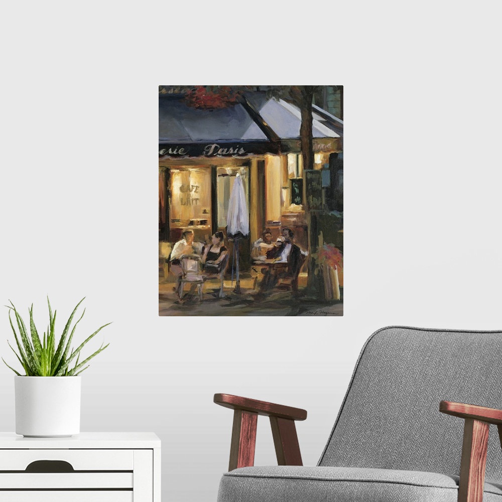 A modern room featuring Painting of street cafo with people sitting outside at tables at night.
