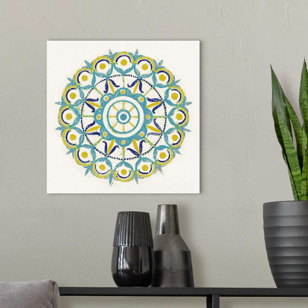 A modern room featuring Square decor with a mandala design in the center made in shades of blue, green, and yellow on a w...