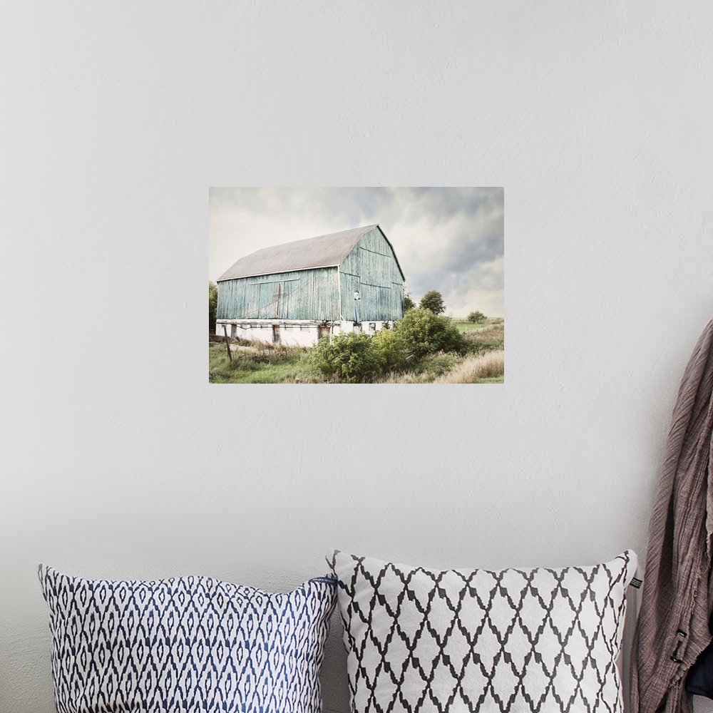 A bohemian room featuring Photograph of an old faded light blue barn in an overgrown rural field.
