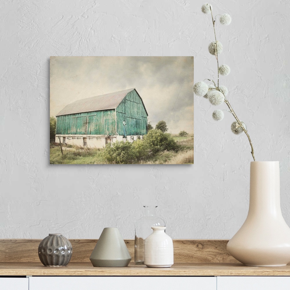 A farmhouse room featuring Rustic photograph with distressed edges of an aged barn in a countryside landscape.
