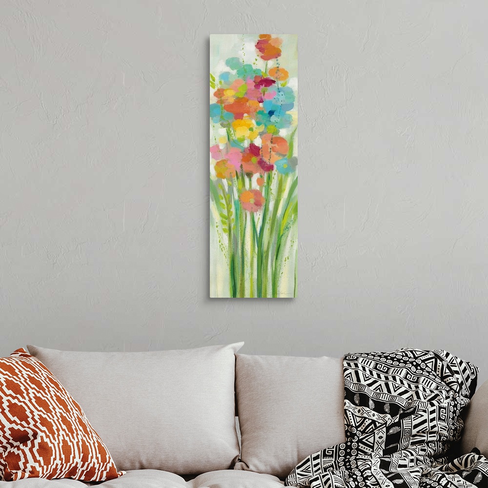A bohemian room featuring A long vertical painting of a group of stemmed flowers and leaves in cheerful colors.
