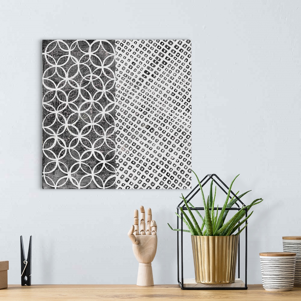 A bohemian room featuring A square decorative image of black and white shapes and patterns within rectangle sections.