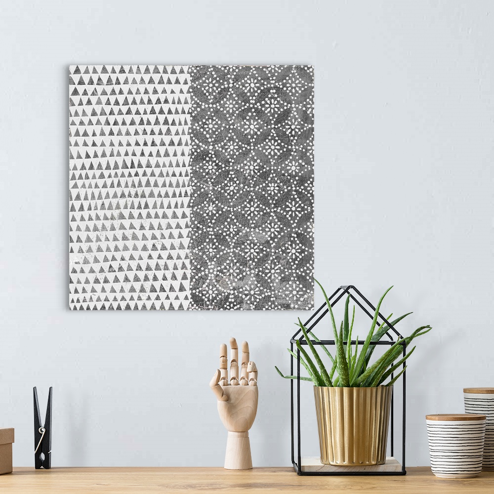 A bohemian room featuring A square decorative image of black and white shapes and patterns within rectangle sections.