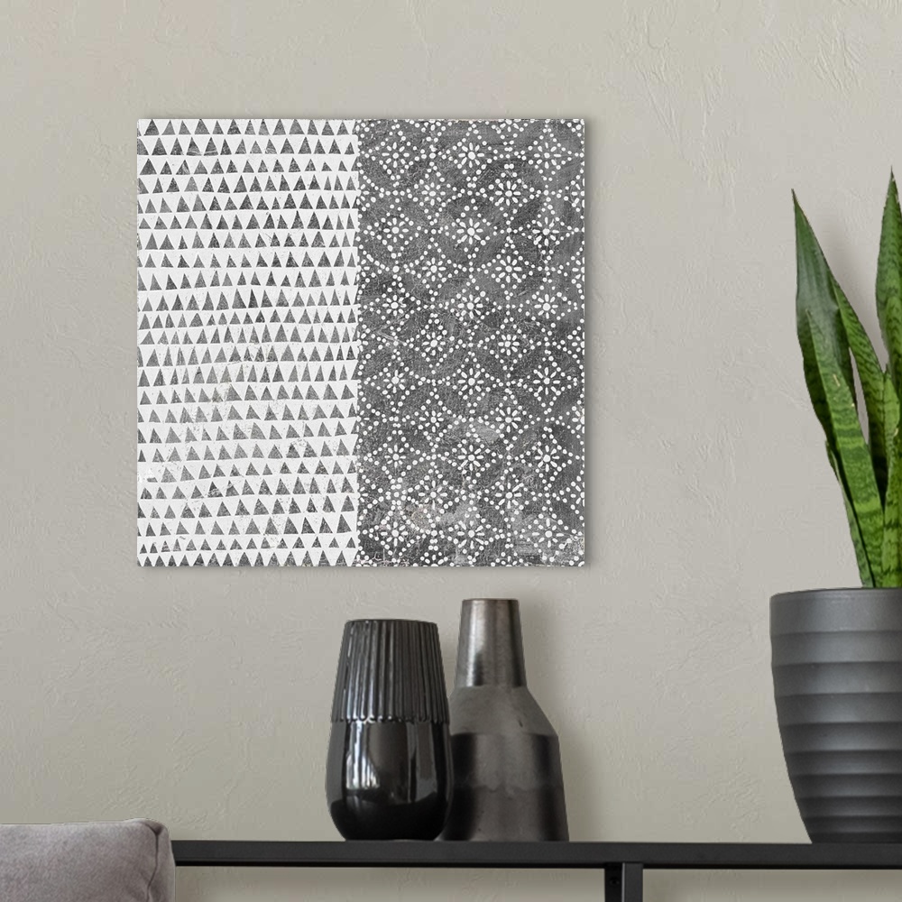 A modern room featuring A square decorative image of black and white shapes and patterns within rectangle sections.