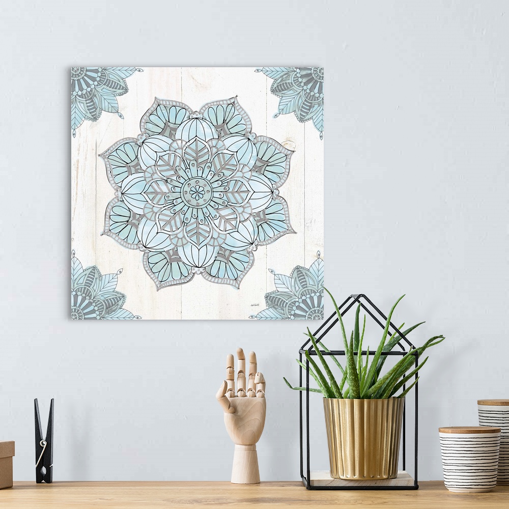 A bohemian room featuring Square artwork of a blue and grey mandala design on a white wood panel background.
