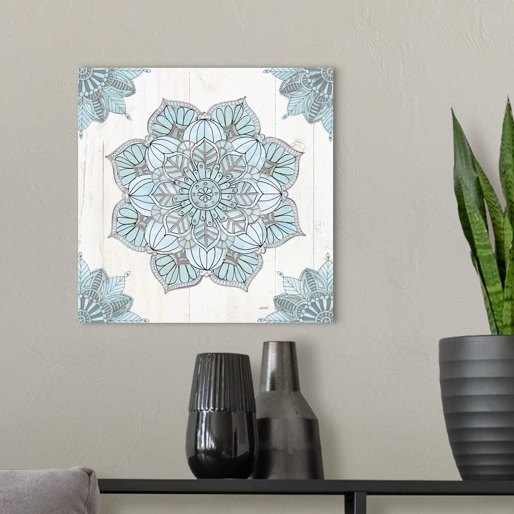 A modern room featuring Square artwork of a blue and grey mandala design on a white wood panel background.