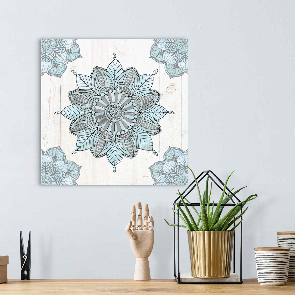 A bohemian room featuring Square artwork of a blue and grey mandala design on a white wood panel background.