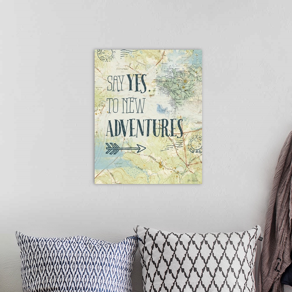 A bohemian room featuring "Say Yes. To New Adventures" written on top of a map and postage stamp collage.