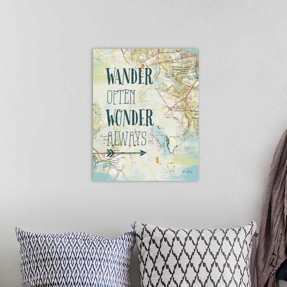 A bohemian room featuring "Wander Often Wonder Always" written on top of a map and postage stamp collage.