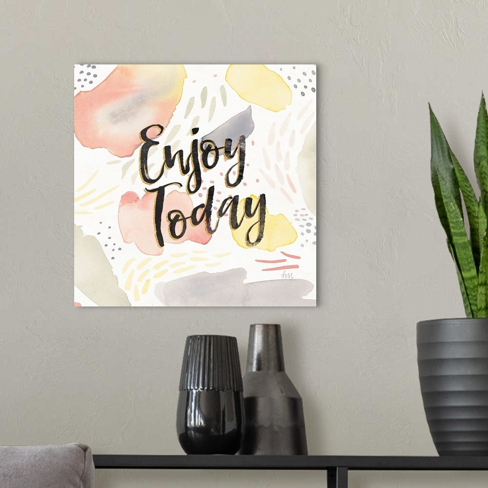 A modern room featuring "Enjoy Today" written in black and gold on a  decorative watercolor background.