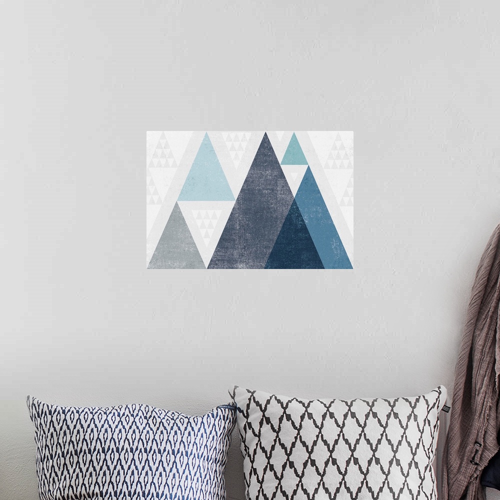 A bohemian room featuring Abstract geometric artwork of a triangle design in cool blue.