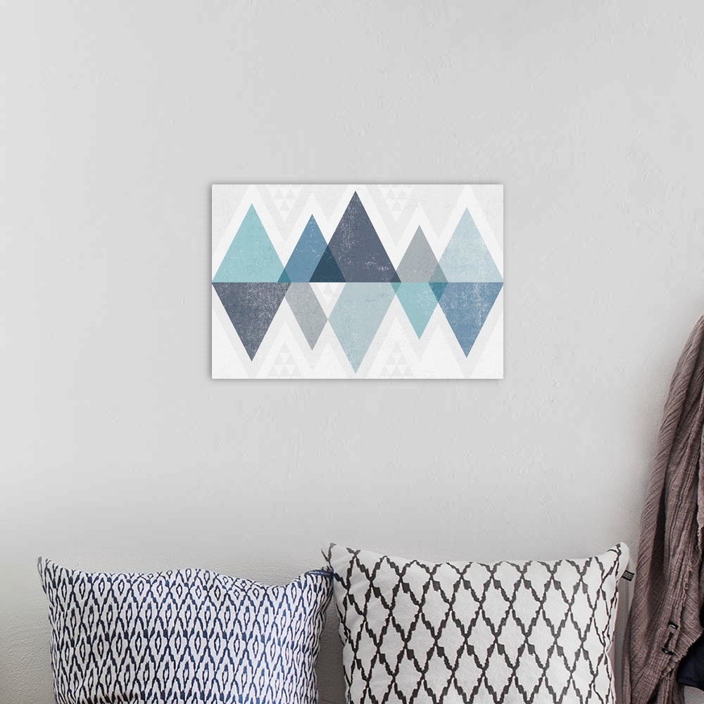 A bohemian room featuring Abstract geometric artwork of a triangle design in cool blue.