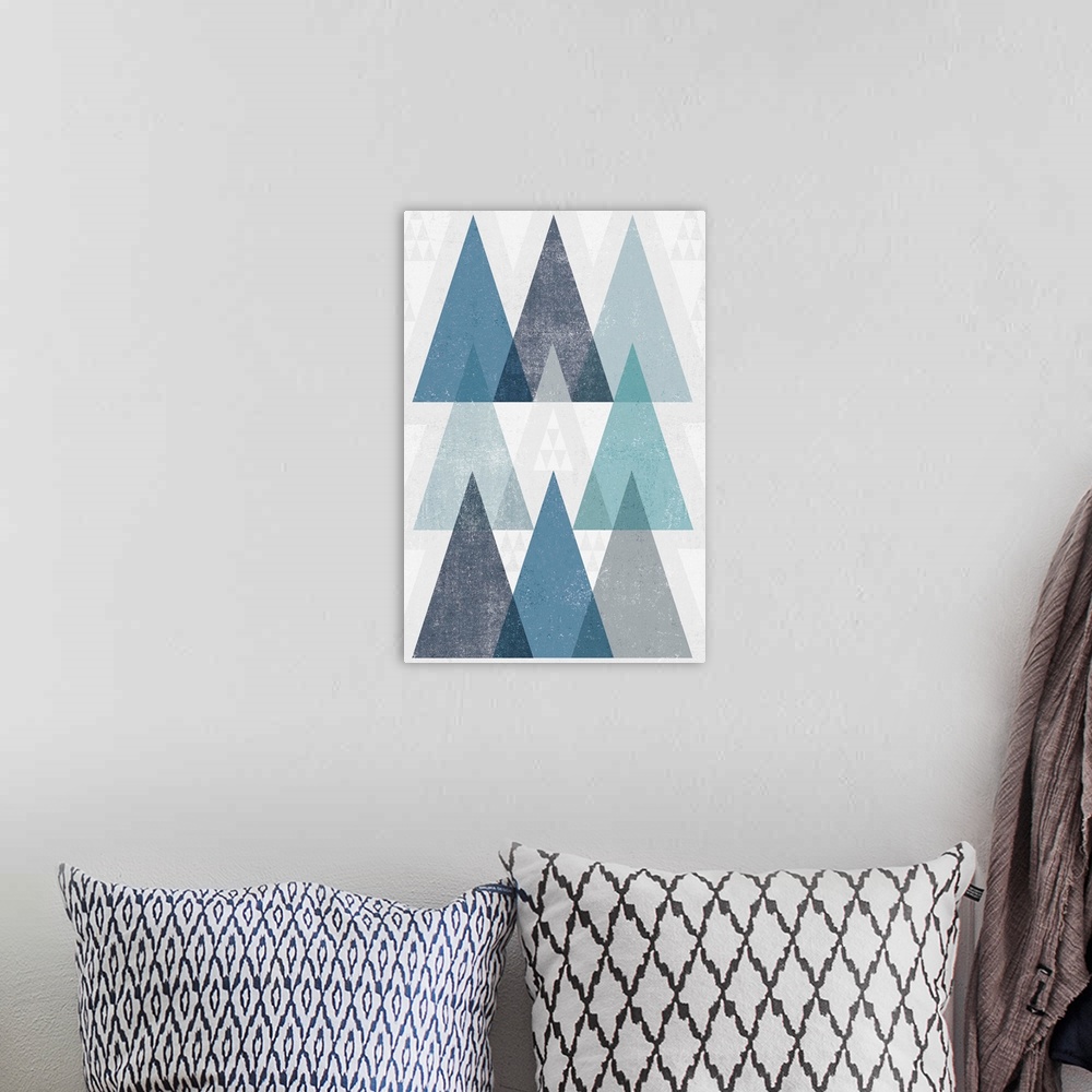 A bohemian room featuring Abstract artwork with a triangle design in cool blue tones.
