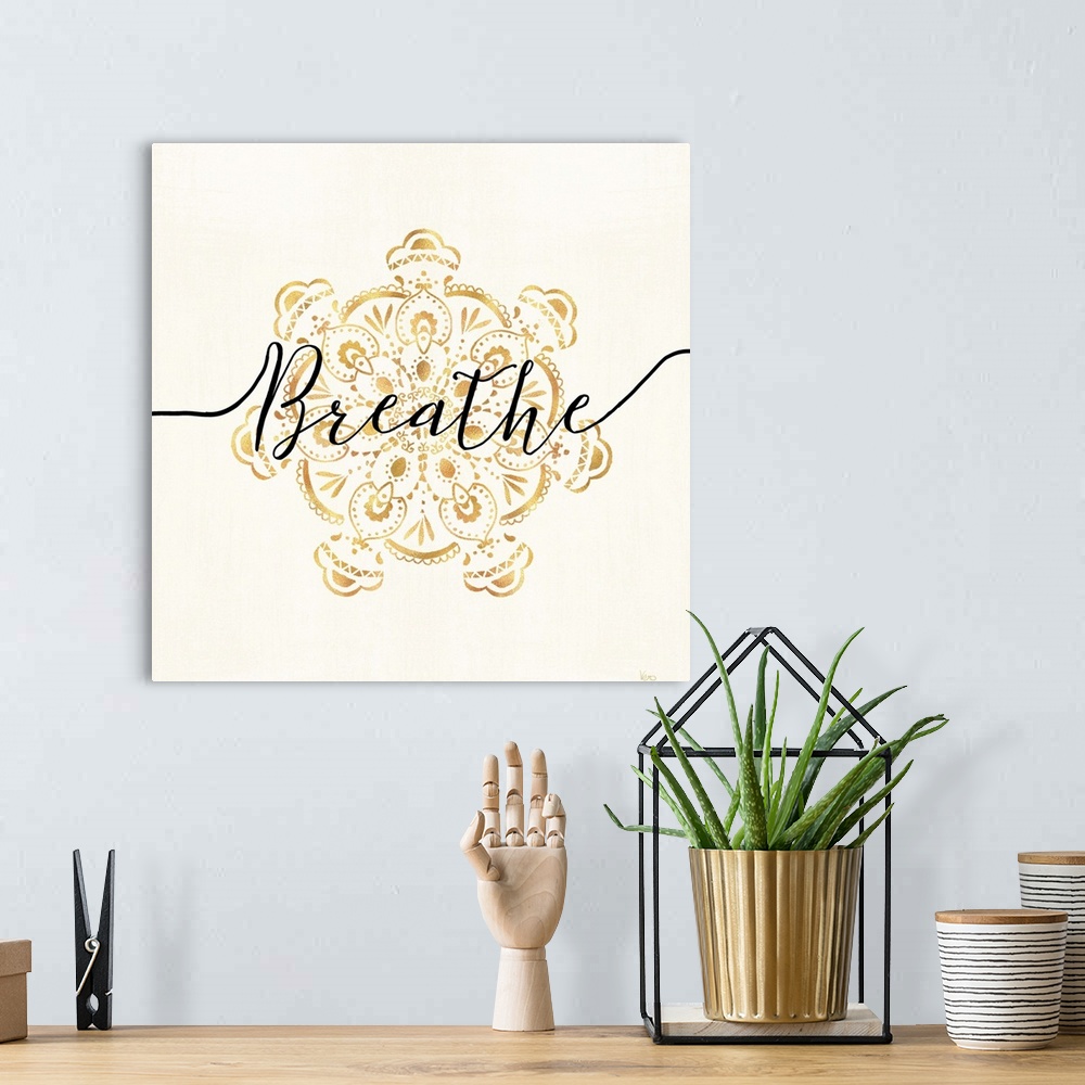 A bohemian room featuring Shiny gold mandala on a neutral background with the word "Breathe" written through the center.