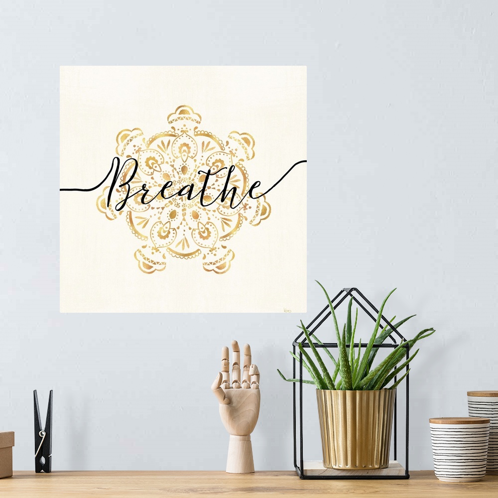 A bohemian room featuring Shiny gold mandala on a neutral background with the word "Breathe" written through the center.