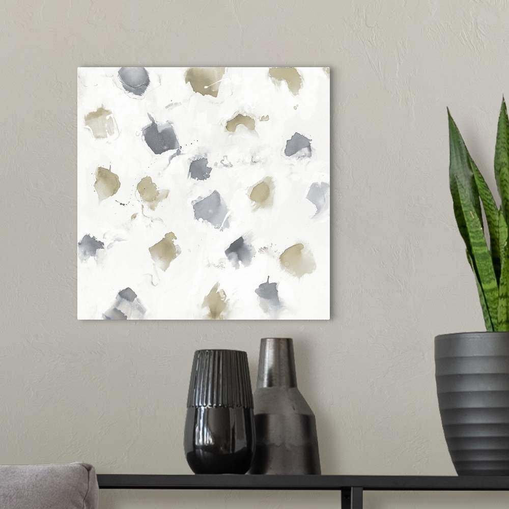 A modern room featuring A square watercolor painting of muted brown and grey spots on white.