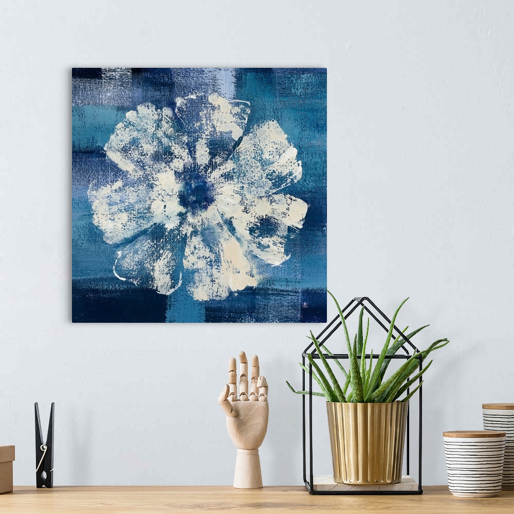 A bohemian room featuring Square decor with a painting of a single white flower on a background made with shades of blue.