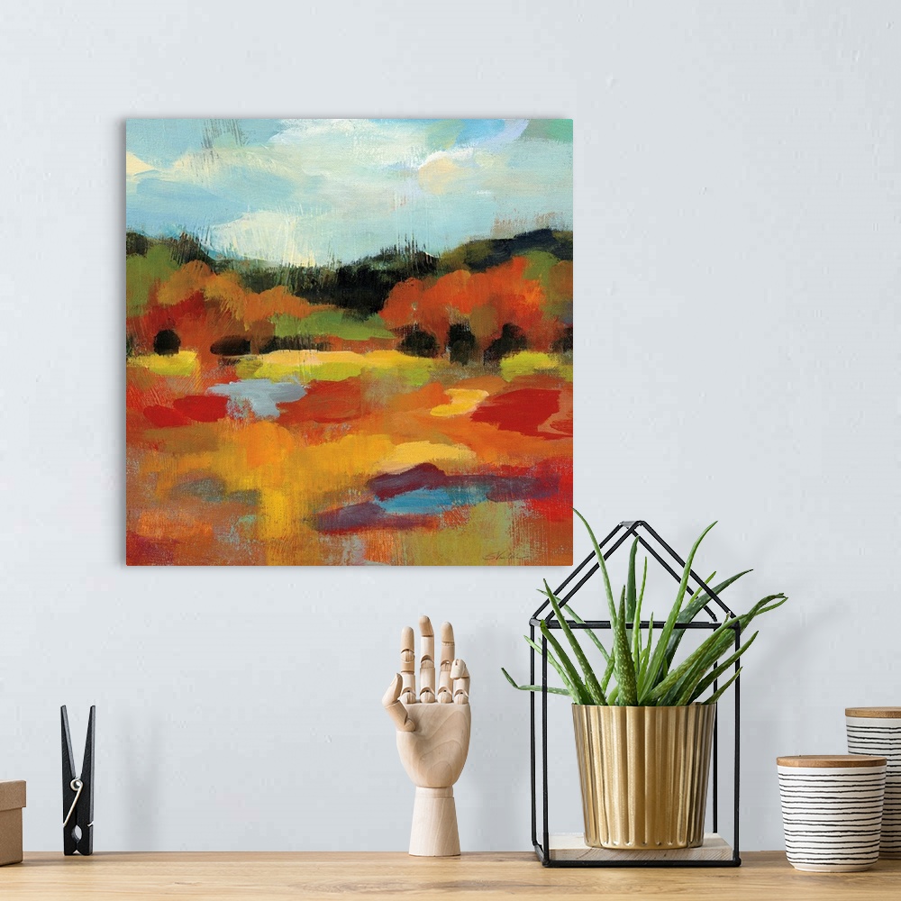 A bohemian room featuring Square abstract painting of an Autumn tree scene with a blue sky.