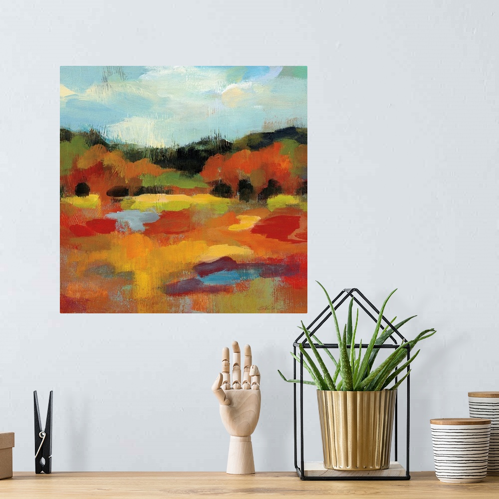 A bohemian room featuring Square abstract painting of an Autumn tree scene with a blue sky.