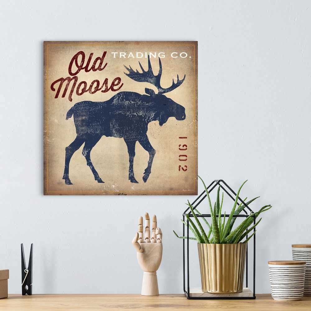 A bohemian room featuring Retro style sign for Old Moose Trading Company, with a blue moose silhouette.