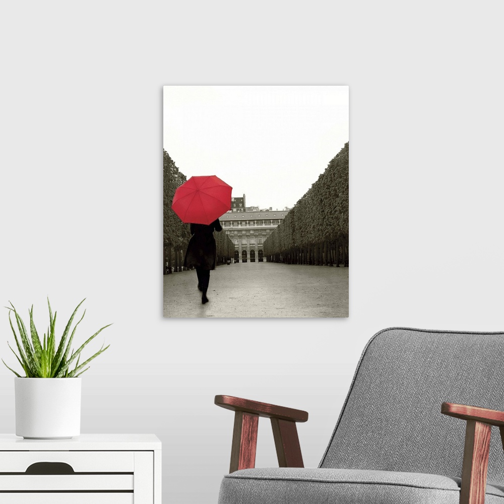 A modern room featuring A photograph of a person walking down an empty road with a red umbrella overhead.