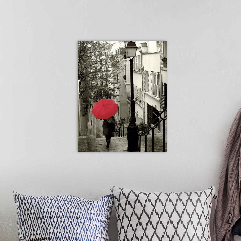 A bohemian room featuring A photograph of a person walking down an empty neighborhood corridor with a red umbrella overhead.