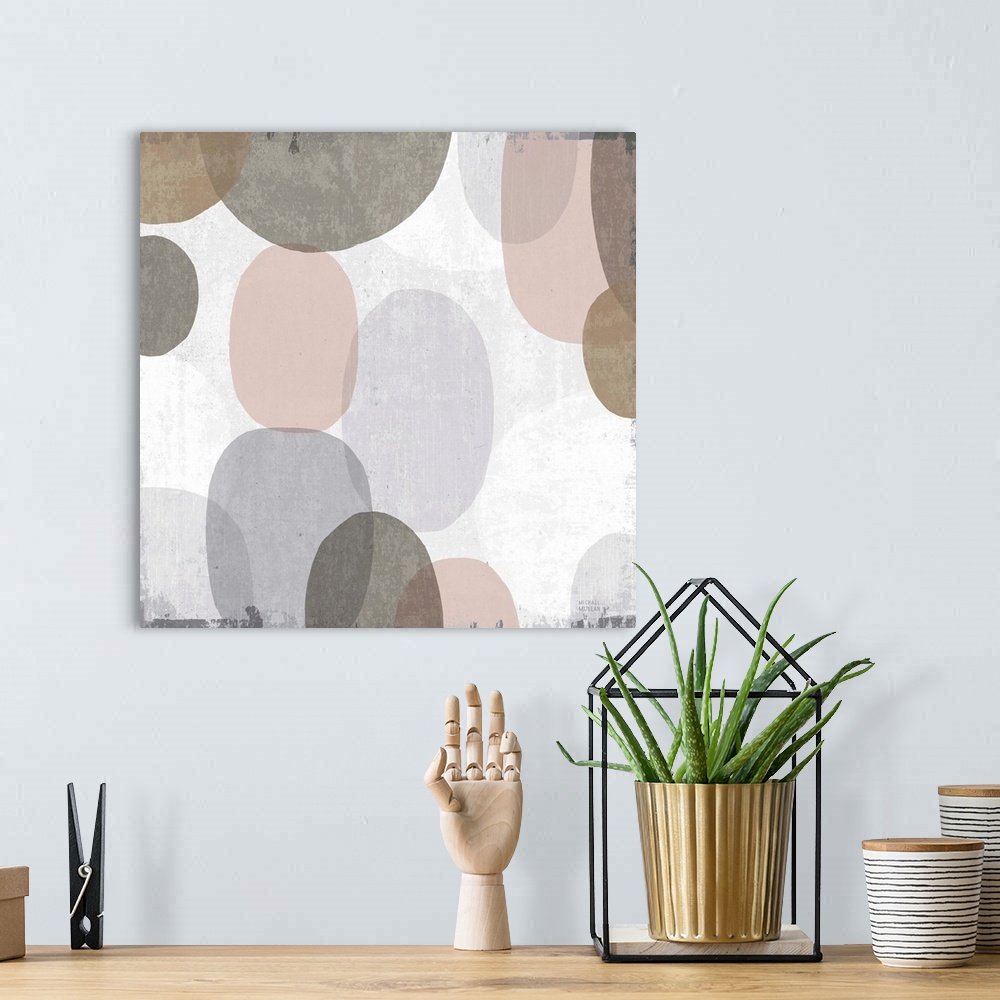 A bohemian room featuring Large abstract artwork with oblong shapes running down the canvas in brown, gray, faded pink, and...