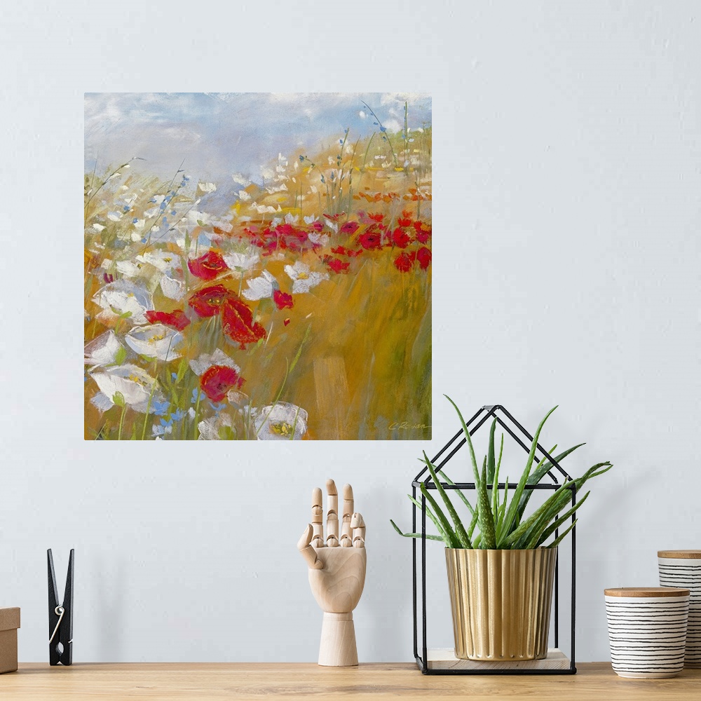 A bohemian room featuring A bright painting in warm colors of red and white flowers in a field under and a blue sky.