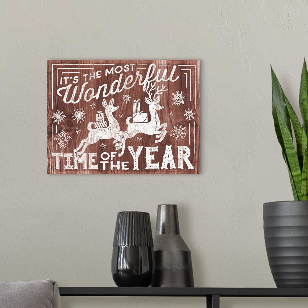 A modern room featuring "It's the Most Wonderful Time of the Year" decorative holiday art on a red wood background.