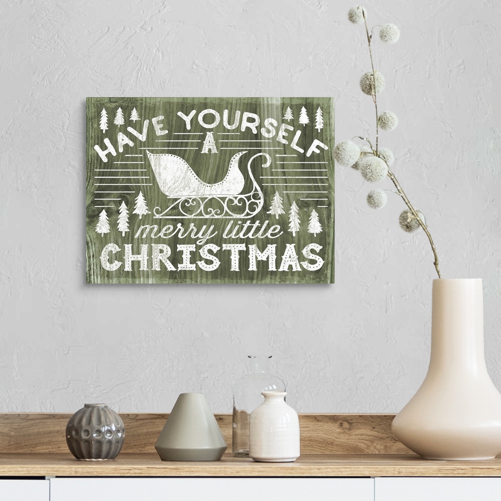 A farmhouse room featuring "Have Yourself a Merry Little Christmas" decorative holiday art on a green wood background.