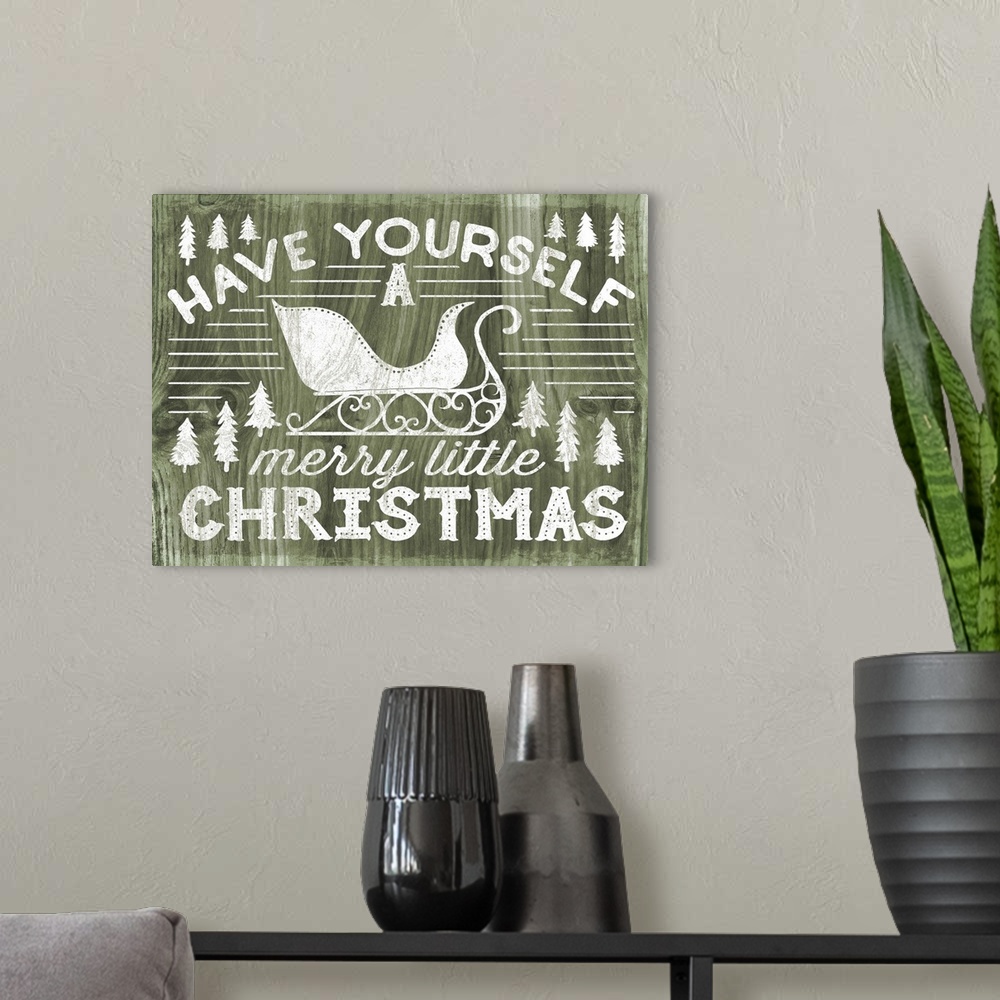 A modern room featuring "Have Yourself a Merry Little Christmas" decorative holiday art on a green wood background.