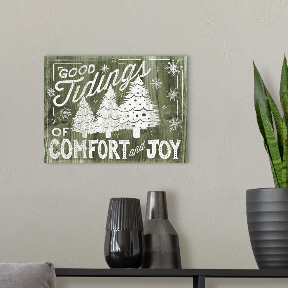A modern room featuring "Good Tidings of Comfort and Joy" decorative holiday art on a green wood background.