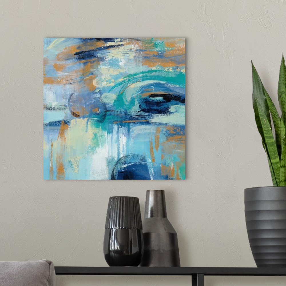 A modern room featuring Square abstract painting if varies shades of blue with orange accents.