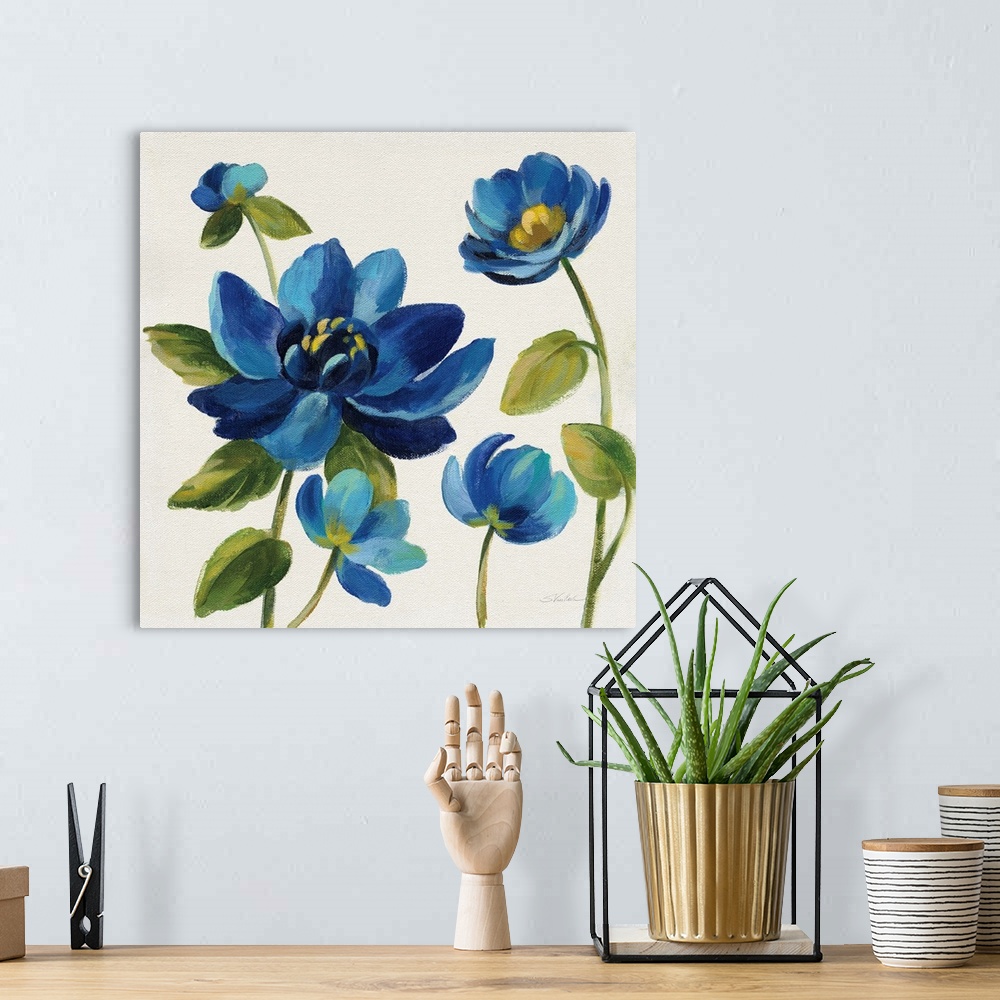 A bohemian room featuring Square painting of blue flowers on an off white background.
