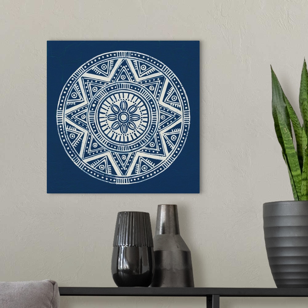 A modern room featuring Square abstract art with a white symmetrically designed mandala on an indigo background.