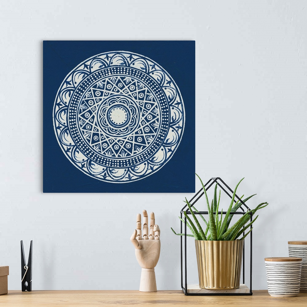 A bohemian room featuring Square abstract art with a white symmetrically designed mandala on an indigo background.