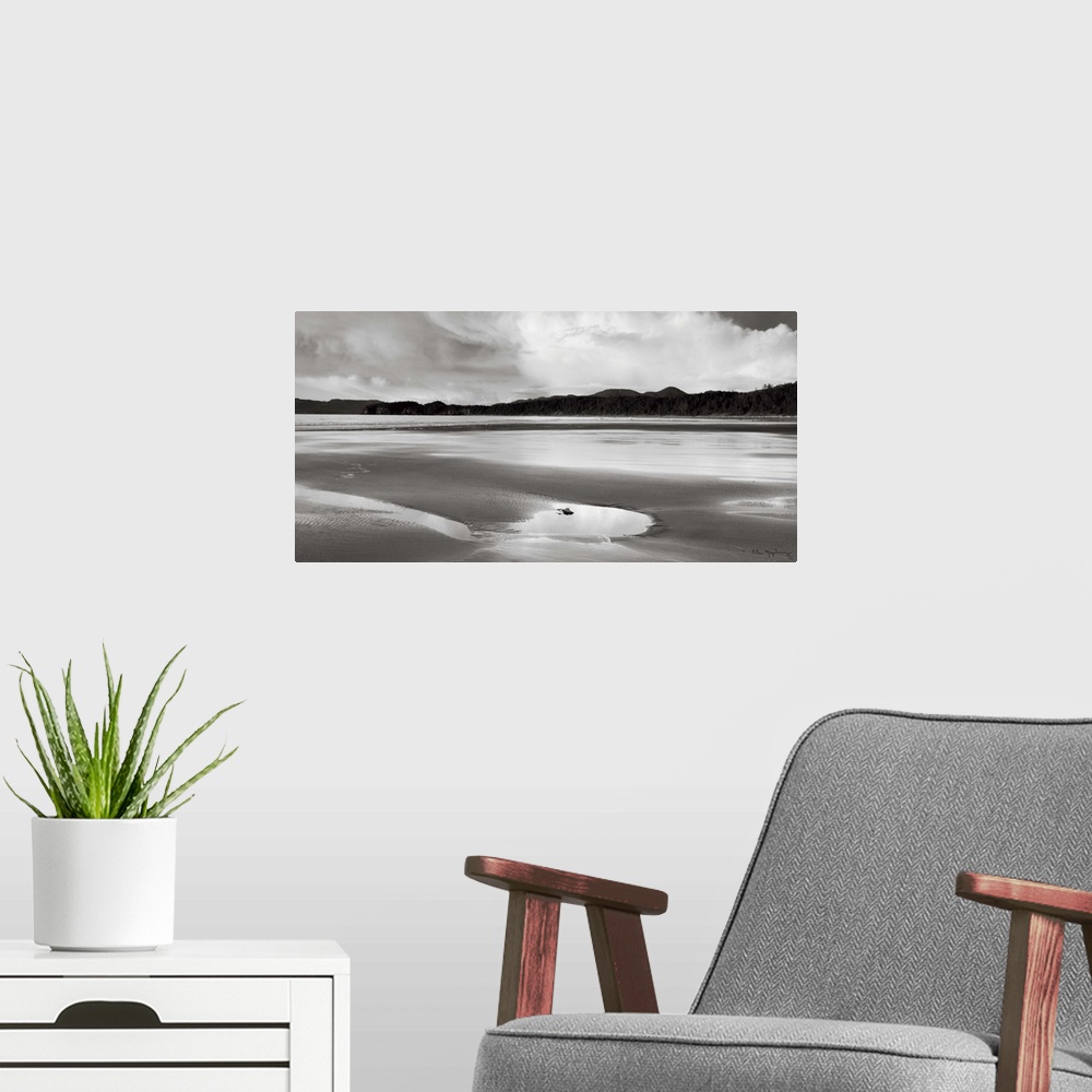 A modern room featuring A black and white photograph of and idyllic beach scene.