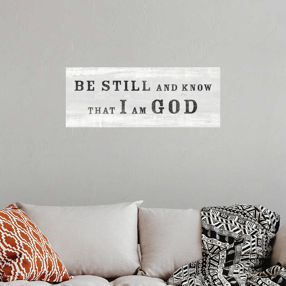 A bohemian room featuring "Be Still And Know That I Am God" against a light gray shiplap background.