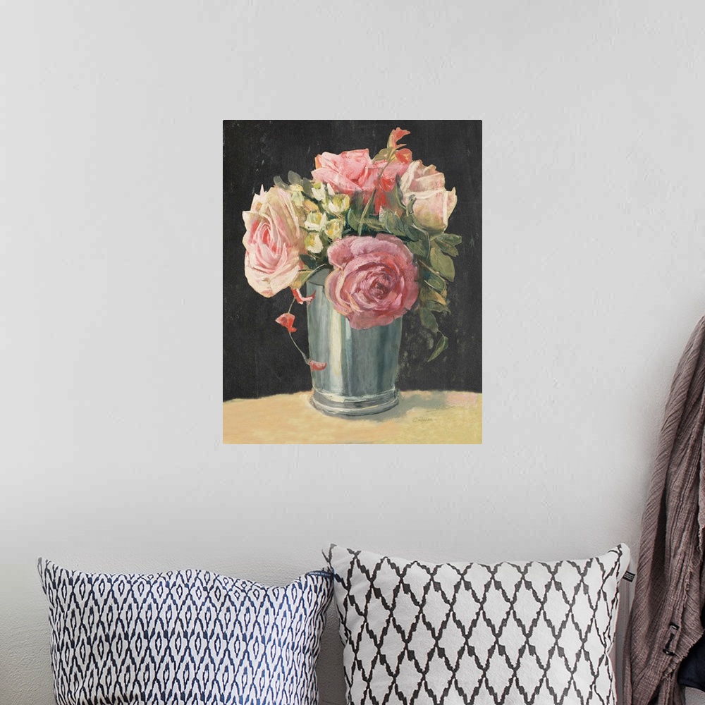 A bohemian room featuring Floral decor with pink roses and greenery in a silver vase on a black background.