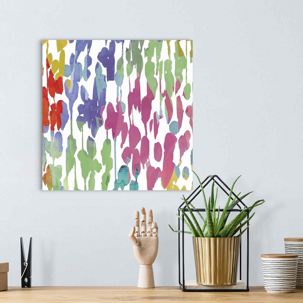 A bohemian room featuring Bright artwork made of varying splatters in rainbow colors.