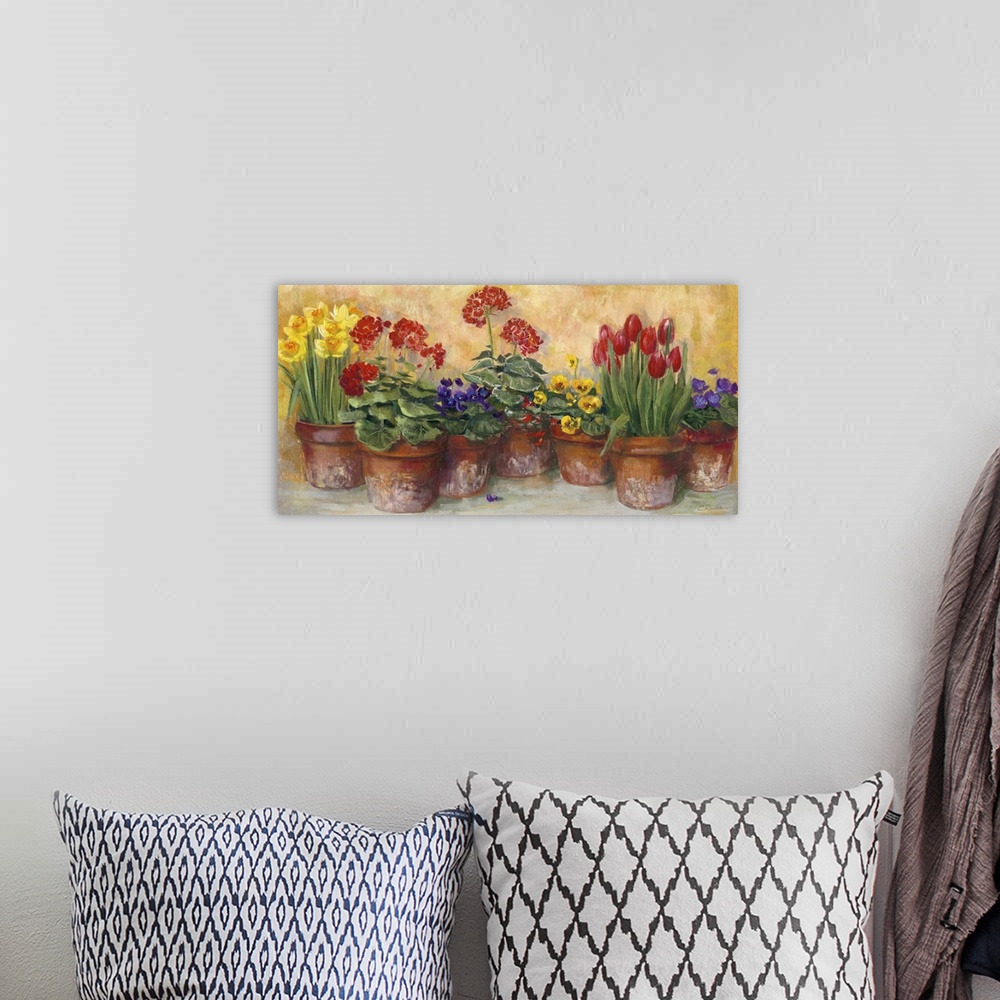 A bohemian room featuring A large horizontal painting of a row of potted flowers in warm colors.