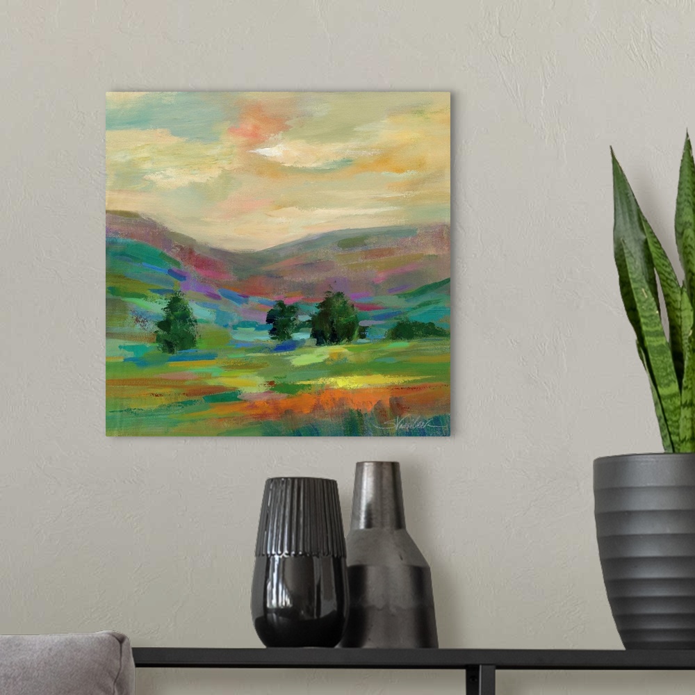 A modern room featuring Contemporary artwork of a hilly landscape with a few trees.