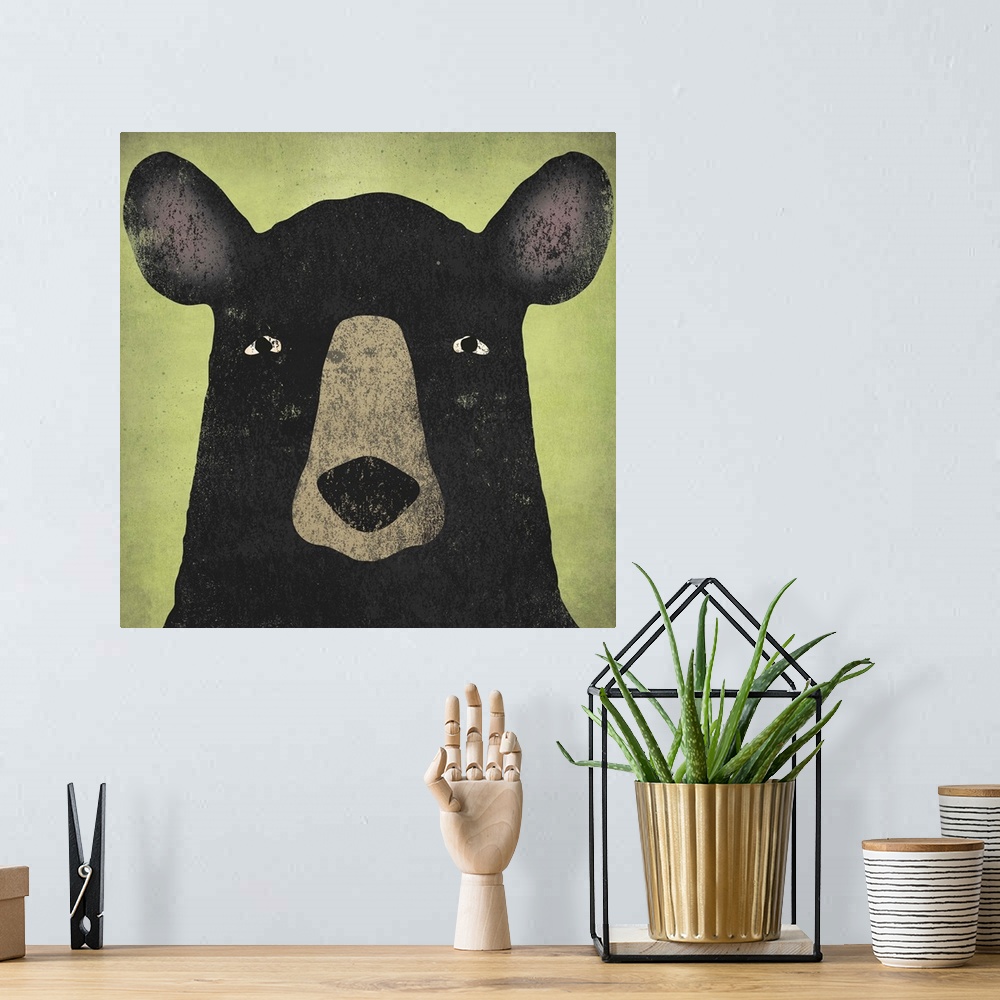 A bohemian room featuring Portrait of a black bear with big ears and an intense stare.