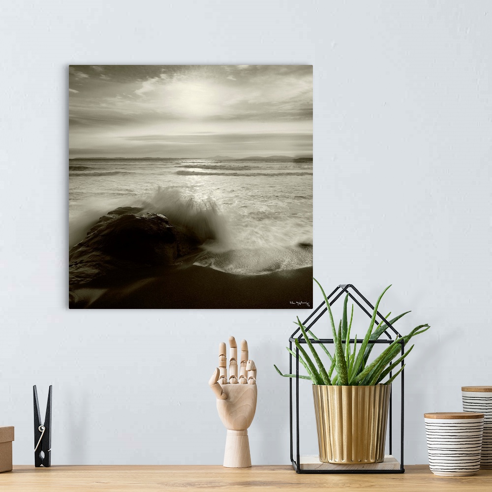 A bohemian room featuring Black and white photograph of a seascape with the ocean waves hitting the rocky shoreline.