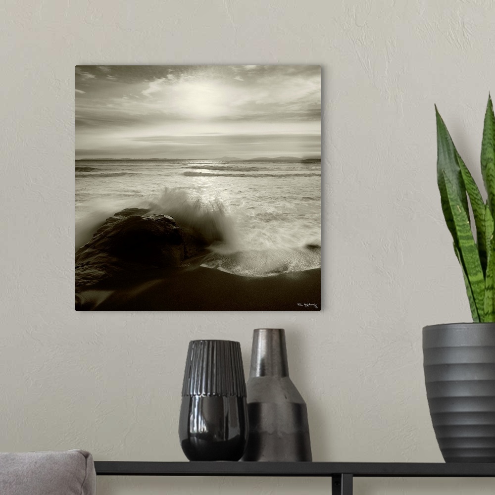 A modern room featuring Black and white photograph of a seascape with the ocean waves hitting the rocky shoreline.