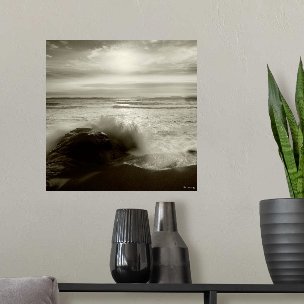 A modern room featuring Black and white photograph of a seascape with the ocean waves hitting the rocky shoreline.