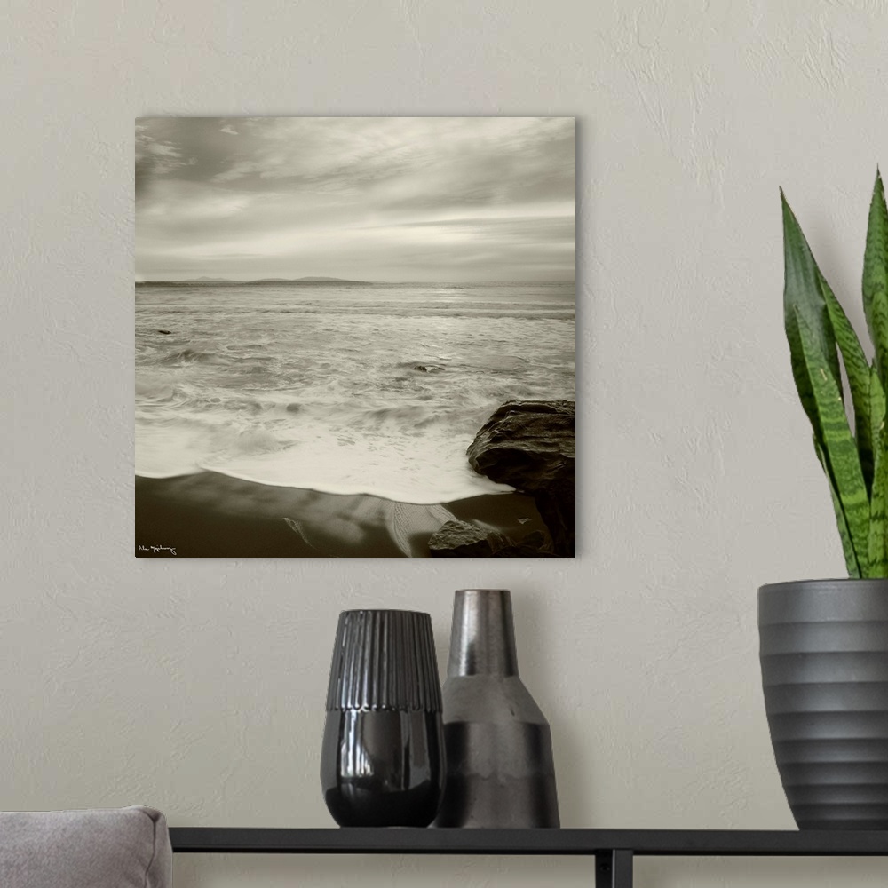 A modern room featuring Black and white photograph of a seascape view from a the shoreline of a beach.